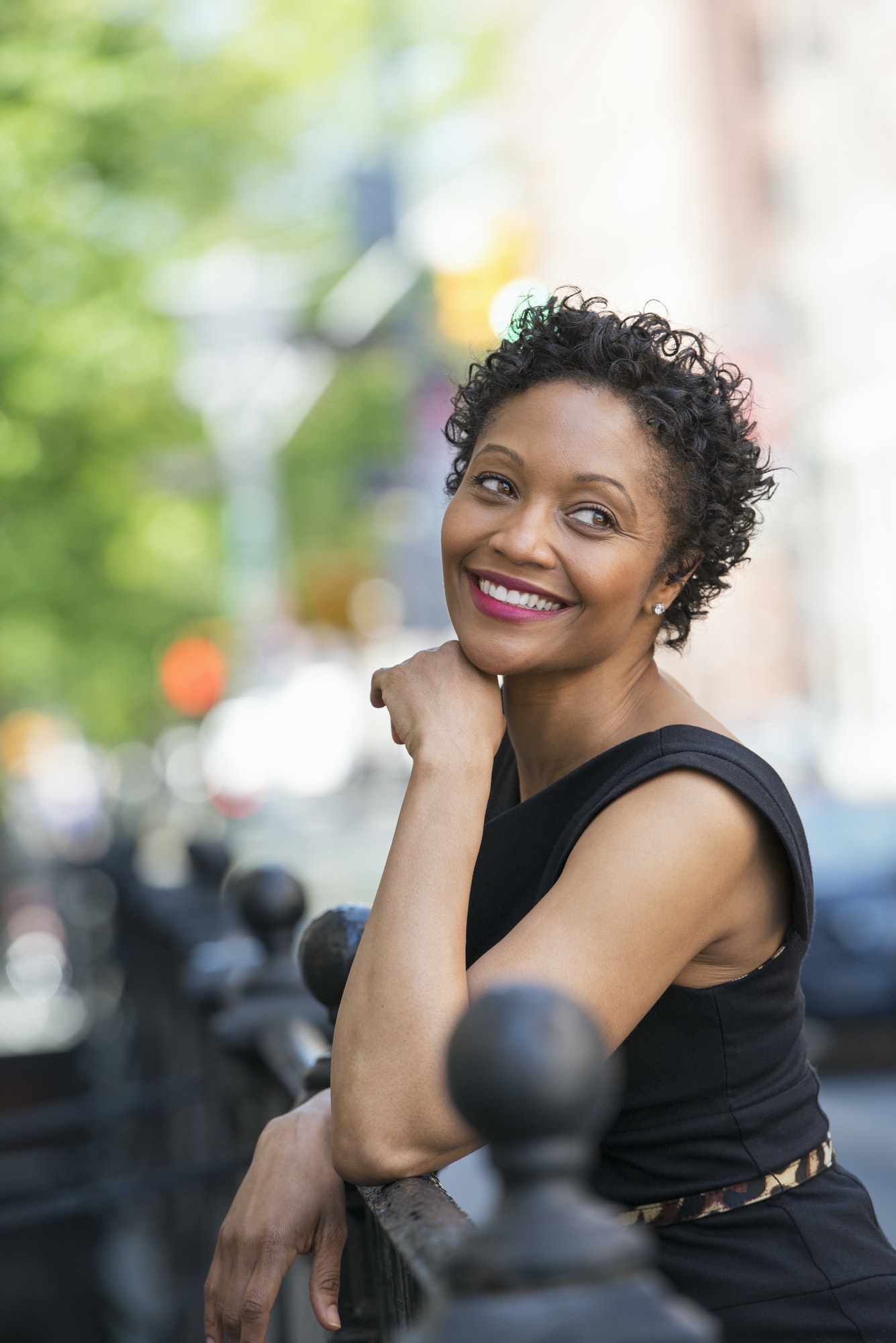 People on the move. A woman in a black dress on a city street.